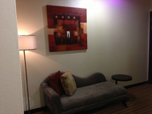 A couch facing a second flatscreen TV in the room