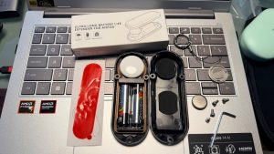 AirTag AA battery extender unboxed contents Unboxed AirTag AA battery extender with AA batteries, shell, screws, tool, and mounting accessories